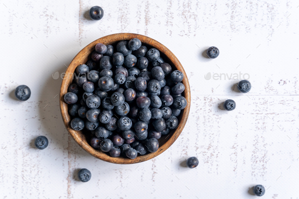 Top down view of a wooden bowl of fresh blueberries on white background - Stock Photo - Images