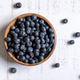 Top down view of a wooden bowl of fresh blueberries on white background - PhotoDune Item for Sale