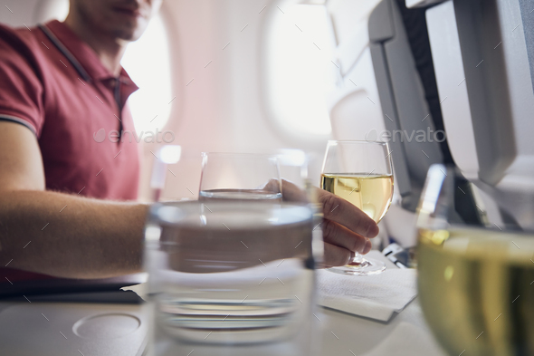 Man enjoying white wine during flight - Stock Photo - Images