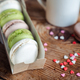 Macaroons in a box, a cup of coffee, a milk jug against the background of small hearts o - PhotoDune Item for Sale