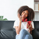 Beautiful young woman student sitting on sofa is video chatting on smartphone, smiling faces and ges - PhotoDune Item for Sale