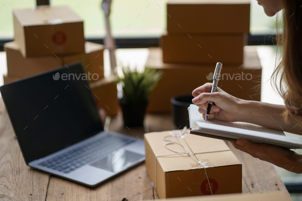 Online business owner woman check customer lists to properly pack and ship to customer
