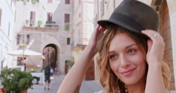 Smiling Woman Puts Hat on Outdoor in Urban Town or Rural City. Woman Wearing Hat outside.Slow Motion alt