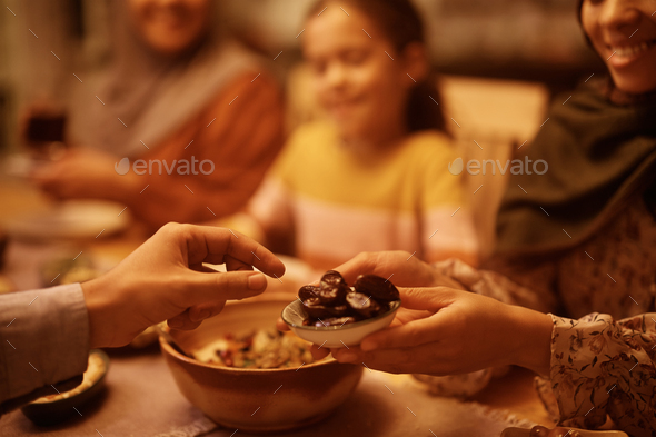 Close up of Muslim couple eating sesame for dessert at dining table. - Stock Photo - Images