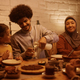 Happy Muslim father pouring milk into daughter&#39;s glass during family dinner at dinning table. - PhotoDune Item for Sale