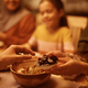 Close up of Muslim couple eating sesame for dessert at dining table. - PhotoDune Item for Sale