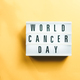 Ribbon for world cancer day on yellow background - PhotoDune Item for Sale