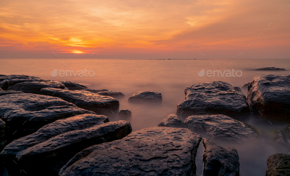 Rocks on stone beach at sunset. Beautiful beach sunset sky. Twilight sea and sky. Tropical sea - Stock Photo - Images