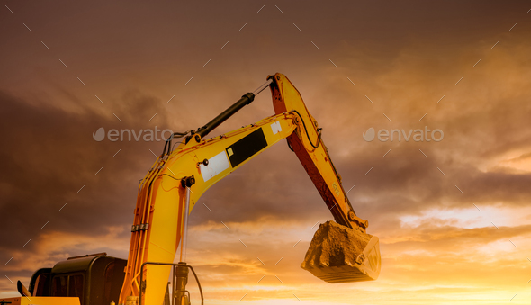 Backhoe working by digging soil at construction site. Closeup hydraulic arm and bucket of backhoe - Stock Photo - Images