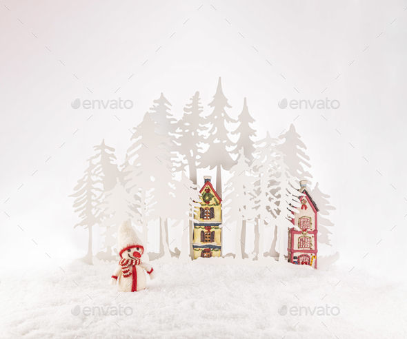 Paper tree cutouts and Christmas ornaments on artificial snow isolated on a white background