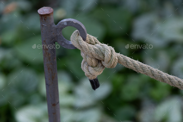 Closeup of a thick rope knot tied to a piece of metal Stock Photo