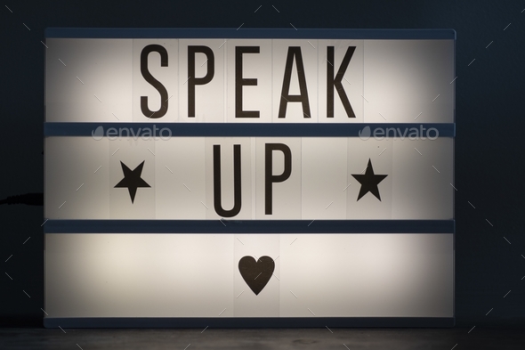 Speak up signage with stars and a heart on an illuminated whiteboard