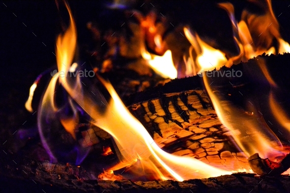 Campfire kettle closeup with blurred bonfire in the background