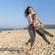 Happy Mother and son running and playing on beach barefoot in a sunny day against the lighthouse - PhotoDune Item for Sale