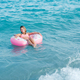 Beautiful young girl with inflatable ring relaxing in the sea - PhotoDune Item for Sale