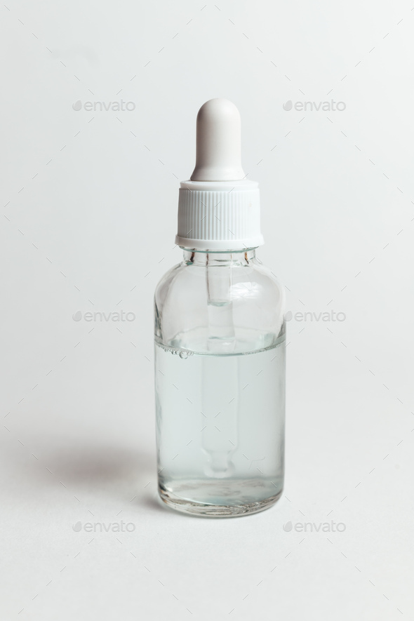 Glass dropper bottle with white cap for cosmetics on white background - Stock Photo - Images