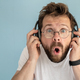 Funny man in headphones listens to music, he is surprised at what he hears - PhotoDune Item for Sale