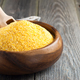 Raw corn grits polenta in a bamboo bowl on the old wooden background. Selective focus - PhotoDune Item for Sale