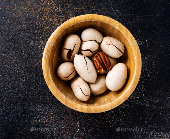 Organic dried pecan in wooden bowl on dark slate background. Top view with copy space. - Stock Photo - Images