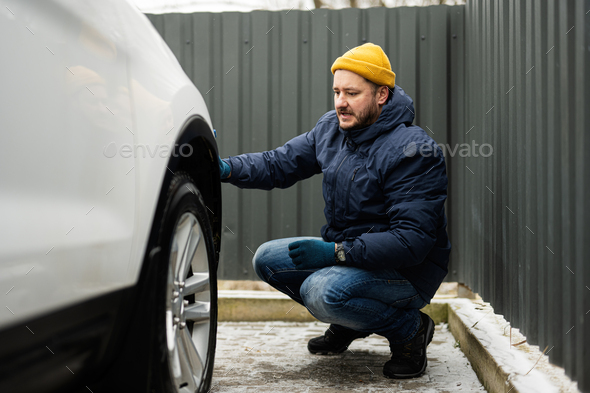 Man wipes american SUV car with a microfiber cloth after washing in cold weather. - Stock Photo - Images