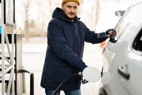 Man refueling his american SUV car at the gas station in cold weather. - Stock Photo - Images
