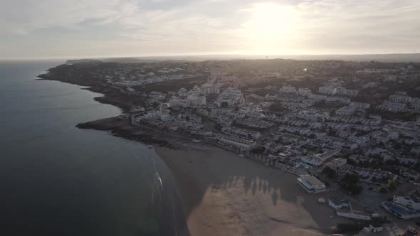 Landscape of sandy beach Praia Da Luz , Algarve. Golden sunset over town and Atlantic Ocean alt