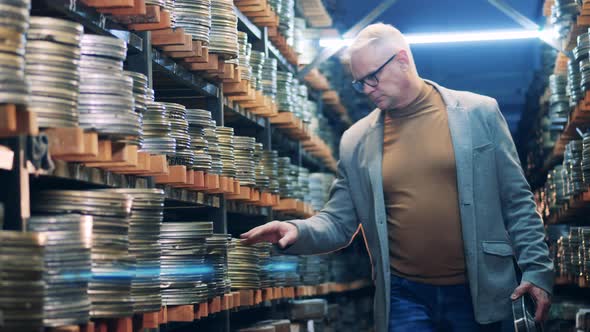 Archive Worker is Putting a Film Tape Into the Case alt