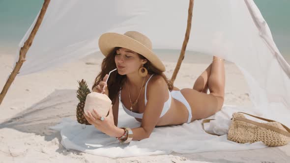 Woman Drinking Coconut Juice While Relaxing on the Beach alt