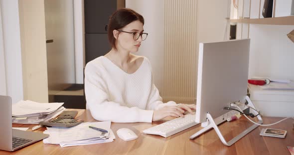 Young Business Woman in Glasses Working in Office Interior on Pc on Desk Typing alt