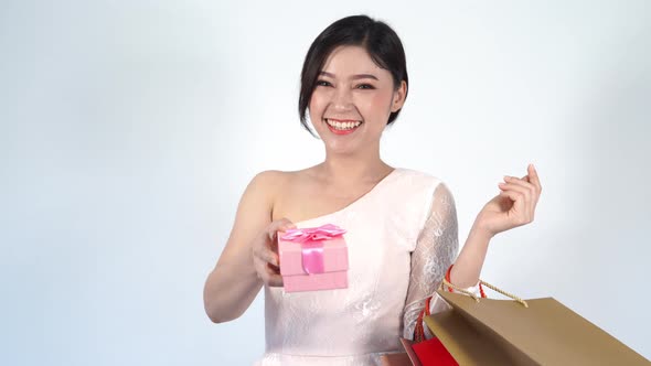young happy woman holding gift box and shopping bag
