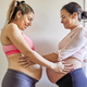 Happy pregnant women toching each others bellies. Multiethnic couple sorority - PhotoDune Item for Sale