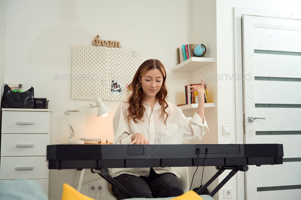 Inspired female composer involved in composing music - Stock Photo - Images