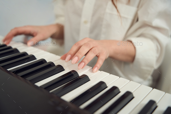 Female composer composing new tune on her synthesizer - Stock Photo - Images