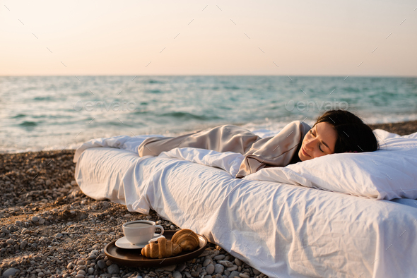 Sleeping woman in bed over sea background - Stock Photo - Images