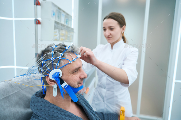 Man in a hospital gown undergoes a check-up in hospital - Stock Photo - Images