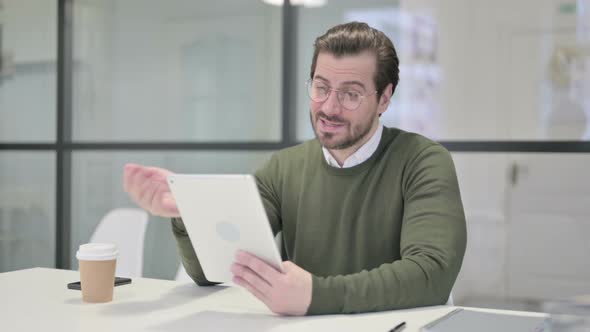 Young Businessman Making Video Call on Tablet in Office alt