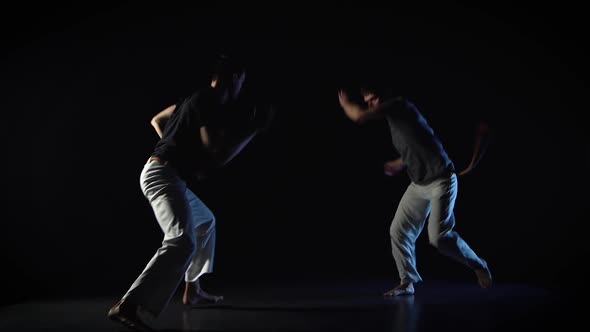 Two Men Are Performing Martial Art of Capoeira. alt