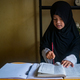 A Muslim girl is learning to read the Koran - PhotoDune Item for Sale