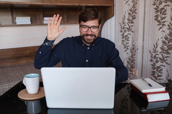 Focused man sitting at desk watching webinar video course - Stock Photo - Images