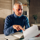 Middle aged man working in a home office and reading paper documents - PhotoDune Item for Sale