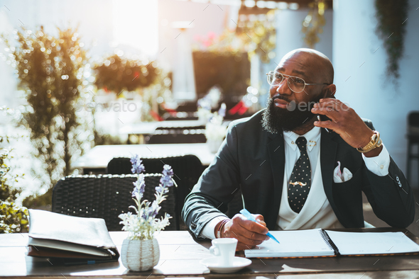 Black businessman in an outdoor cafe - Stock Photo - Images
