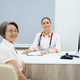 Two women in good mood are sitting in doctor office - PhotoDune Item for Sale