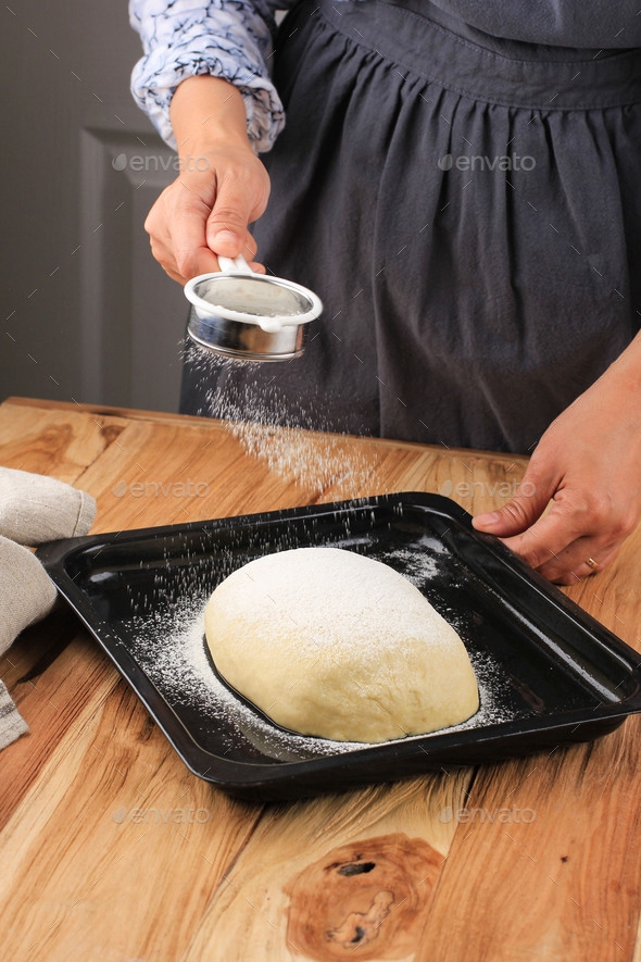 Female Bakers Hold Strainer Coating Raw Bread Dough with Flour Stock