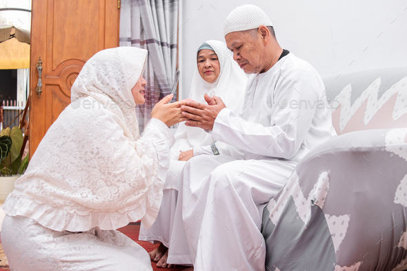 Muslim woman kneeling down to her father