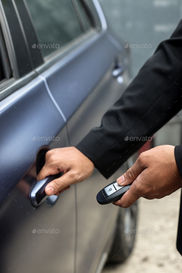 hand pressing on car key and pull handle car