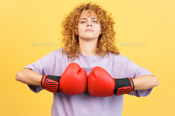 Rude woman in boxing gloves looking at camera