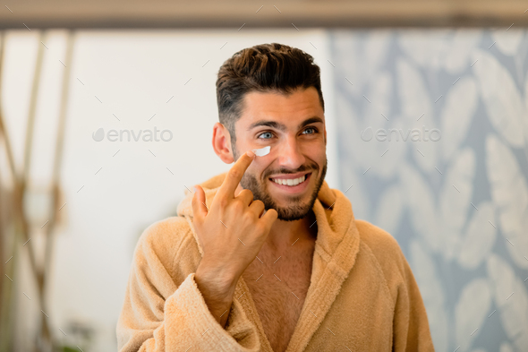 Man smearing cream on face - Stock Photo - Images