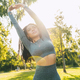 Woman does gym stretching exercises outdoor in a sunny day - PhotoDune Item for Sale