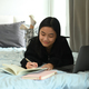 Young woman during study online on laptop and making notes on notepad.  - PhotoDune Item for Sale
