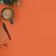 Top view of cup of coffee, pen, notebook, flowerpot and keyboard on orange background.  - PhotoDune Item for Sale